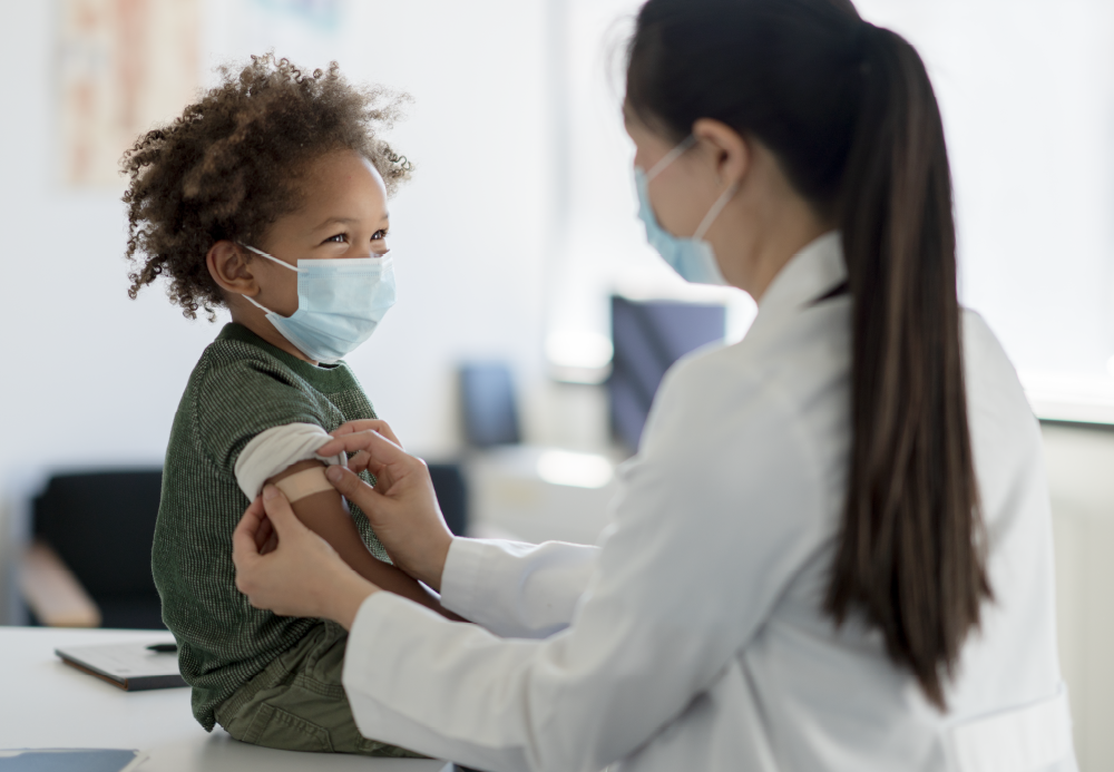 Photo of doctor placing bandage on child's arm 