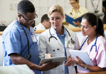 Image of a doctor and two nurses looking at a clipboard