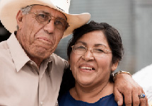 Man with arm around woman, couple looks to be of Hispanic heritage