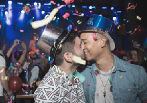 Two young men at a party kissing