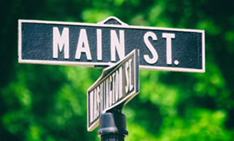 An intersection street sign with one of the street names 'Main St.'
