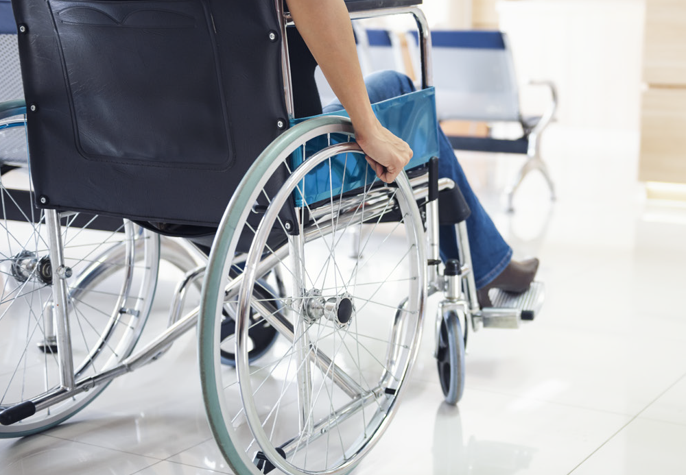 Back view of a patient wheeling himself in a wheel chair