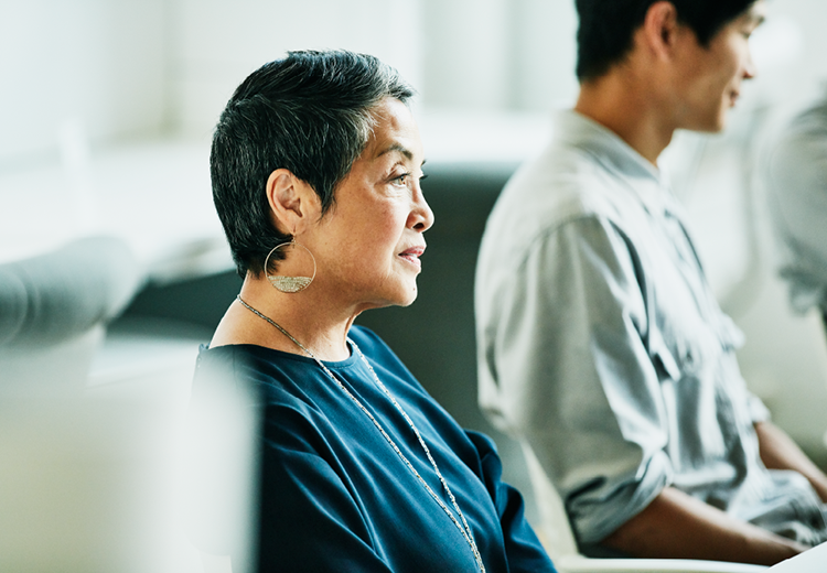 A middle age Asian woman and younger Asian man sitting in a waiting room