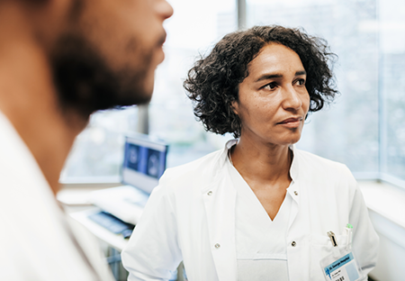 A man and woman in medical coats looking to the side