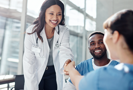 Smiling female doctor shaking hands with a nurse