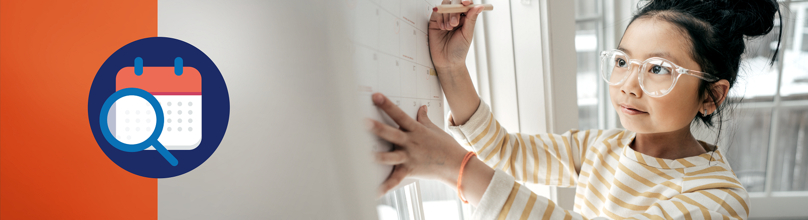 Young girl marking a calendar with a pencil