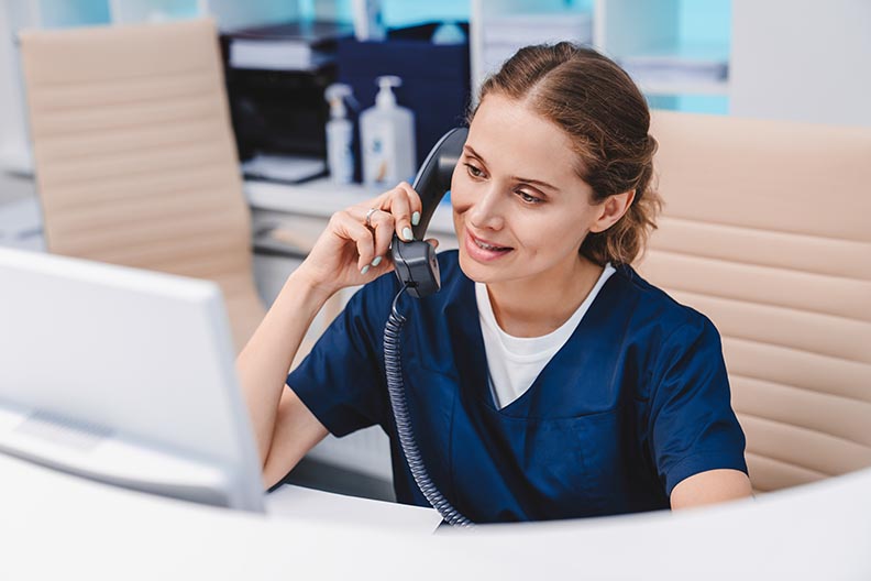 Photo of healthcare worker at a desk on the phone