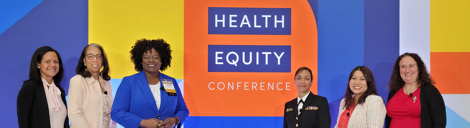 Six conference members posing in front of a Health Equity Conference wall